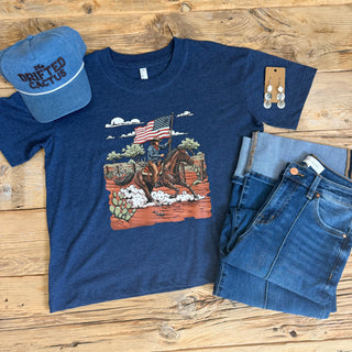Navy tee with a graphic of a cowboy riding a horse with an American Flag. 
