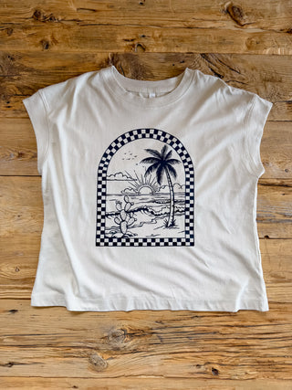 off white women's relaxed fit shirt with a black checkered arch design with beach scene on the inner part of the arch.