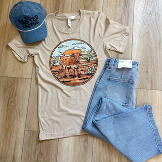 tan -tshirt with a longhorn standing on south texas landscape 