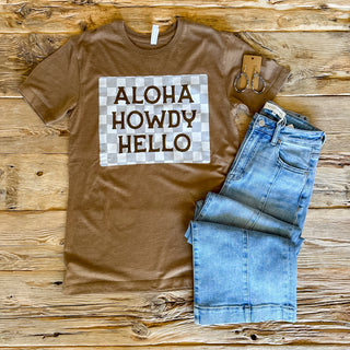 Brown tee with a checkered graphic with Aloha Howdy Hello on top of the checkered print. 