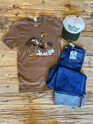 brown t-shirt with a graphic of a cowboy riding a horse near a cactus. 