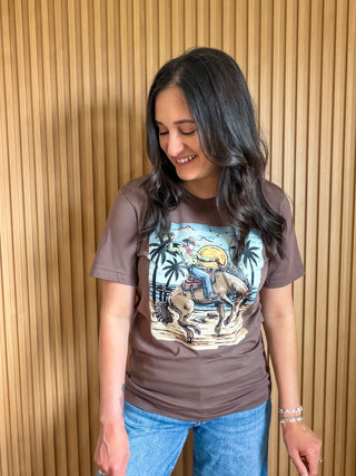 Brown t-shirt with a coastal cowboy design( cowboy riding a horse on the beach).