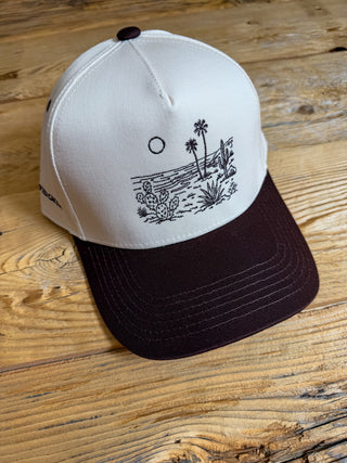brown/khaki hat with brown embroidery design of cactus and palms on the beach. 