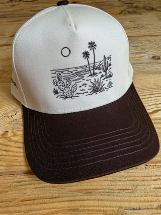 brown/khaki hat with brown embroidery design of cactus and palms on the beach. 