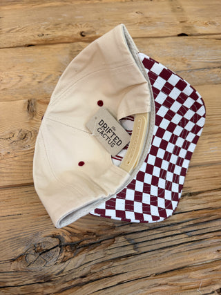 The back of the beige hat with the checkered brim. 