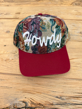 A floral trucker hat with a burgundy brim and white embroidered 'Howdy' text on the front. 