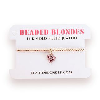 Gold bracelet with a A&M Texas dangle charm. 